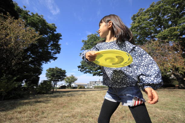 istock Japanese student girl playing flying disc (8 years old) 1440902068
