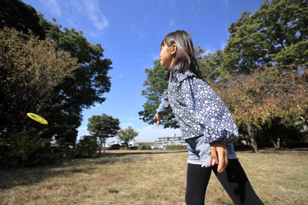 istock Japanese student girl playing flying disc (8 years old) 1440902575