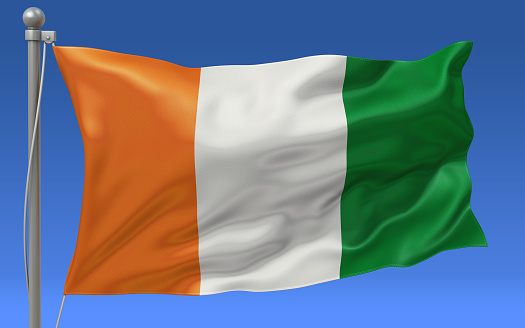 Ivory Coast -Cote D’Ivoire- flag waving on the flagpole on a sky background