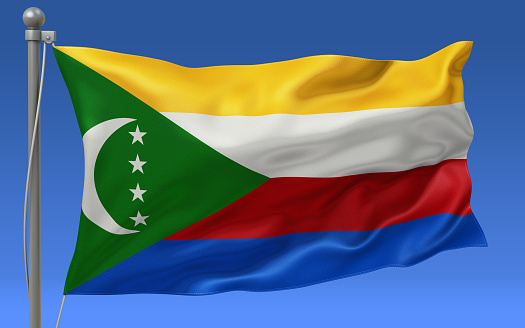 Comoros flag waving on the flagpole on a sky background