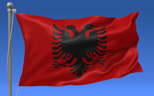 Albania flag waving on the flagpole on a sky background
