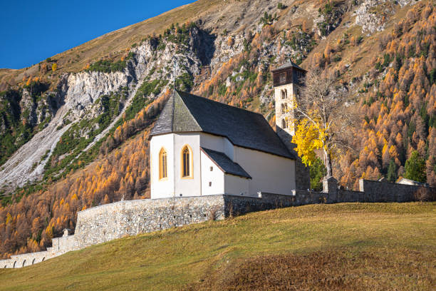 Church and Cemetery in the Swiss Alps Samedan, Switzerland - October 2022: San Peter Church and Cemetery near the town of Samedan in Engadin Valley, Switzerland. samedan stock pictures, royalty-free photos & images