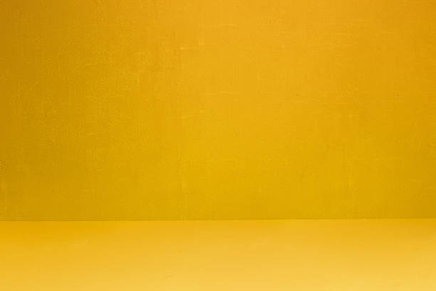 istock Yellow textured wall and floor with some small white spots and dirt. 1440908974