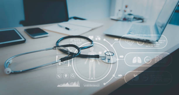 Stethoscope with computer laptop on doctor desk at hospital clinic with hologram futuristic graphic, Digital healthcare technology concept stock photo