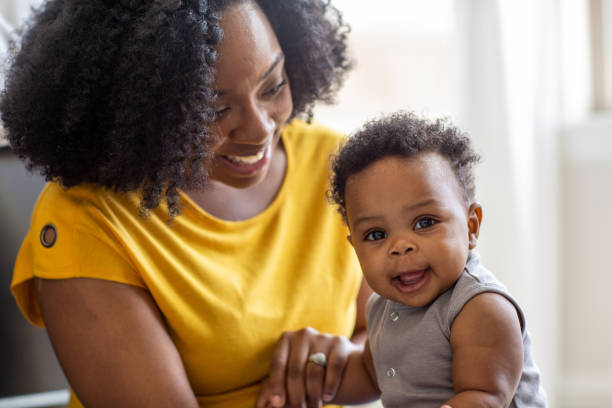 幸せな母親は、自宅で彼女の息子と笑顔と遊んでいます。 - baby mother newborn african descent ストックフォトと画像