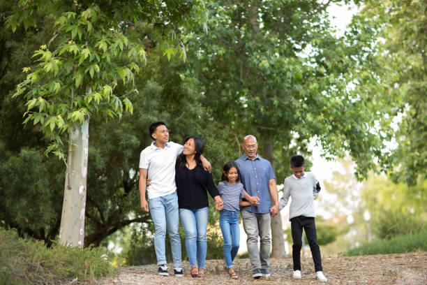 Happy Asian family walking and talking outside. Asian family taking a walk outside and talking. happy filipino family stock pictures, royalty-free photos & images