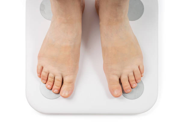 istock Bare Feet on Weight Scale Isolated, Overweight Control, Obese Problem, Lost Weight Concept 1440915494