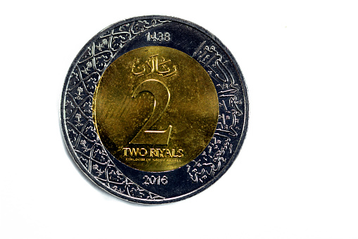 Reverse side of 2 SAR two Saudi Arabia riyals coin series 1438 AH 2016 with multiple coat of arms within the floral ornamentation and inscription of the kingdom of Saudi Arabia 2 riyal isolated, selective focus
