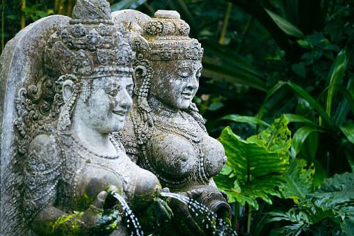 Traditional sculptures made of stone seen in the jungle of the Bali island, Indonesia.