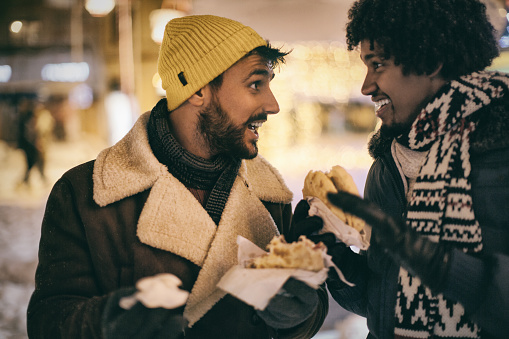 Friends enjoying street food during a winter night.