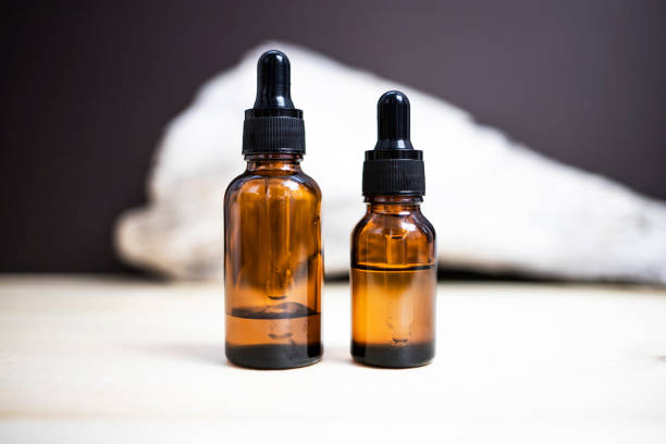 istock Glass dropper bottles on an abstract background. Side view, place for text. 1440920827