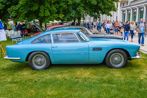 Baden-Baden, Germany - 14 July 2019: light blue Aston Martin DB4 coupe 1958 1963 is parked in Kurpark in Baden-Baden at the exhibition of old cars \