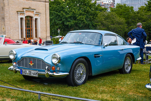Baden-Baden, Germany - 14 July 2019: light blue Aston Martin DB4 coupe 1958 1963 is parked in Kurpark in Baden-Baden at the exhibition of old cars \