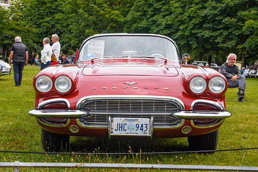 Baden-Baden, Germany - 14 July 2019: red white Chevrolet Corvette C1 Convertible 1961 cabrio roadster is parked in Kurpark in Baden-Baden at the exhibition of old cars \