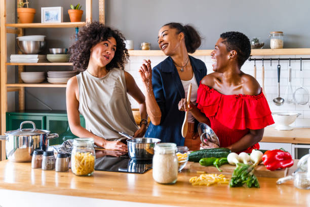 Three mixed race hispanic and black women bonding at home stock photo