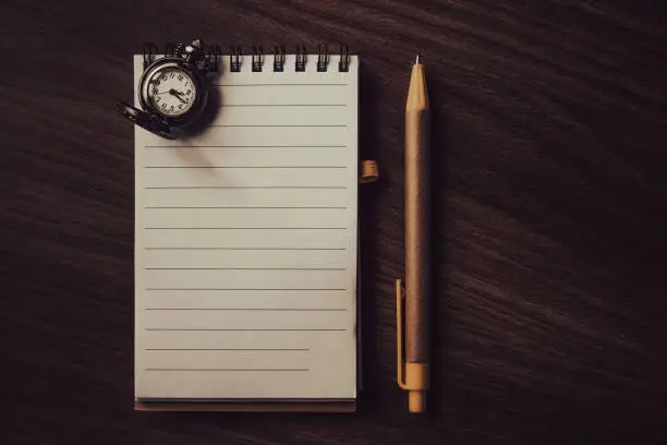 Blank lined notepad made of recycled paper with pen and pocket watch