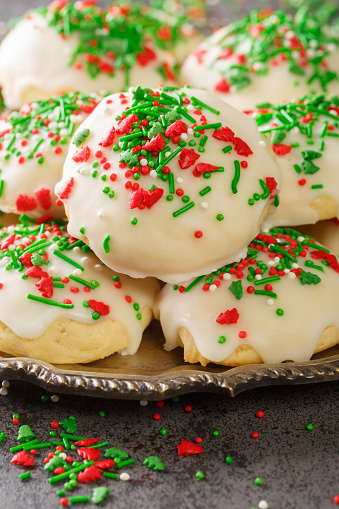 Italian Christmas Cookies are soft, buttery, fluffy with a hint of vanilla closeup in the plate on the table. Vertical