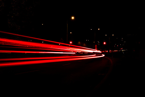istock Lights of cars at night. Street line lights. Night highway city. Long exposure photograph night road. Colored bands of red light trails on the road. Background wallpaper defocused 1440937439