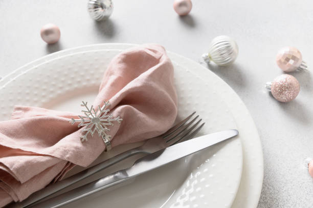 istock Christmas festive table setting with pink ball and napkin on gray table. 1440938680