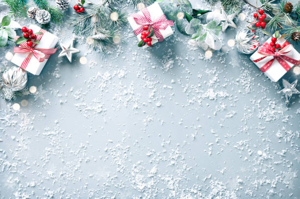 istock Winter fir branches, evergreen plants, berries, gift boxes and decorations on snowy background 1440938990