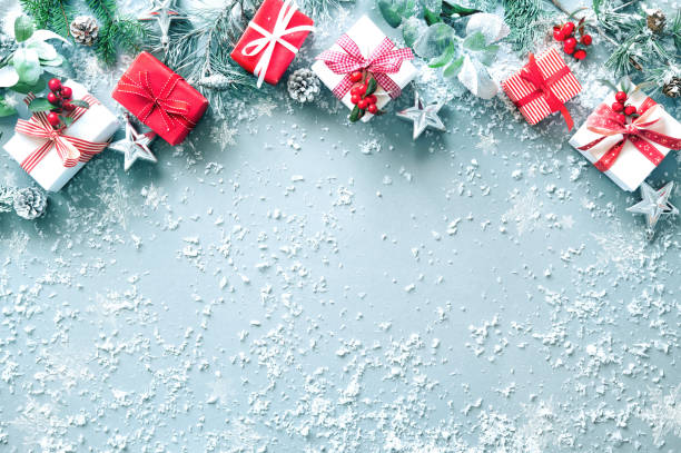 istock Winter fir branches, evergreen plants, berries, gift boxes and decorations on snowy background 1440938994