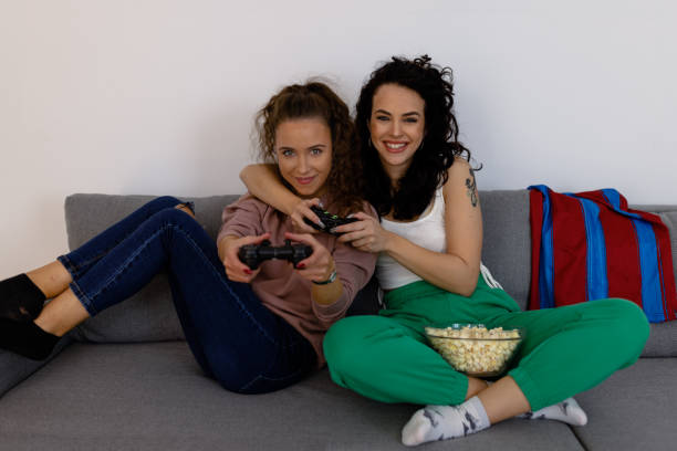 istock A beautiful young woman is playing computer games with her best friend. 1440940272