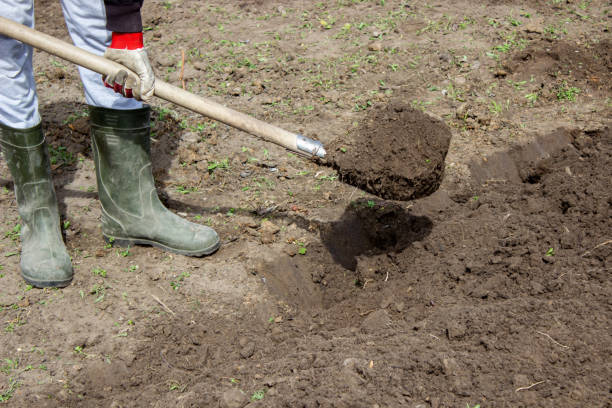 istock Farmer in rubber boots with garden tools in the garden, 1440942876