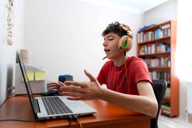 istock The boy playing computer games in his room is talking to his playmates. 1440945108