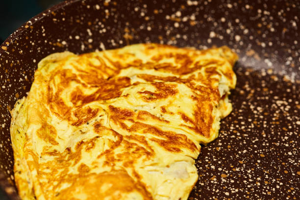 Omelet cooking in a pan in a domestic kitchen stock photo