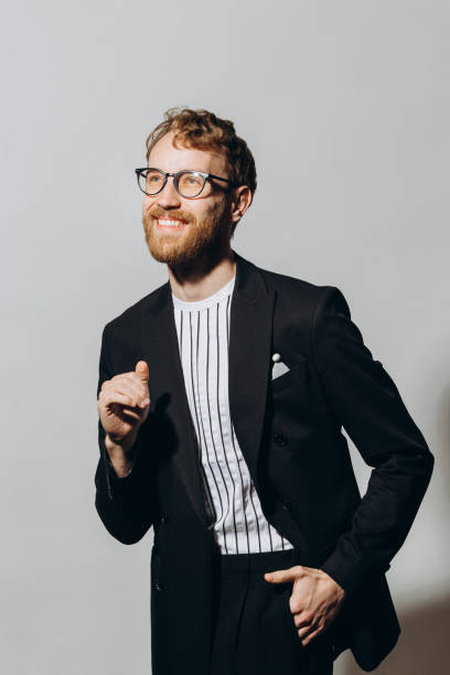 istock Celebration concept. Stylish red-haired young man in a black jacket isolated on a white background. 1440948863