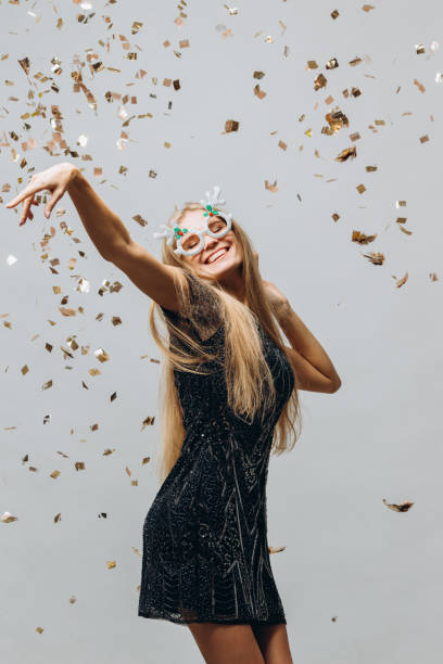 New years young woman having fun in xmas party with confetti New years young woman having fun in xmas party with confetti New Year’s Eve Outfit stock pictures, royalty-free photos & images