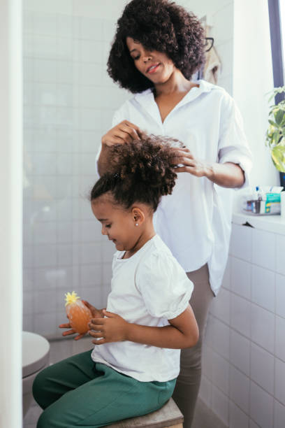 istock Mother Tying Her Daughter's Hair 1440949786