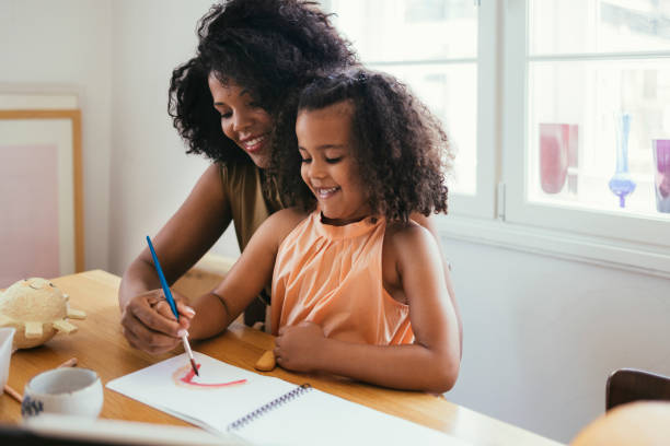 istock Mother And Her Daughter Drawing Together 1440949835