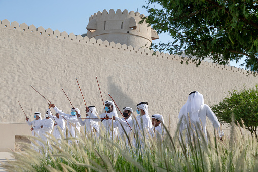 Abu Dhabi, UAE - May 14, 2021: Group of men performing traditional Emirati Al Ayalah dance at Al Hosn Festival. High resolution photo.