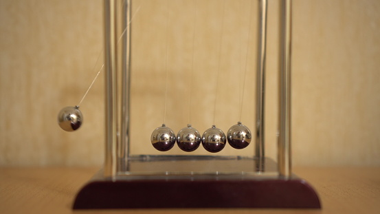 Pendulum consisting of colliding metal spheres creating perpetual motion.