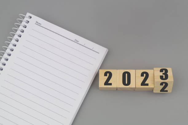 istock Numbers 2022 and 2023 with blank notebook on gray background. 1440953045