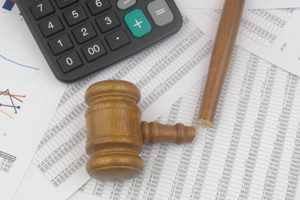 istock Broken judge gavel and calculators on financial documents. 1440953432