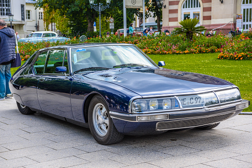 Baden-Baden, Germany - 14 July 2019: dark blue Citroen SM coupe 1970 1975 with opened hood is parked in Kurpark in Baden-Baden at the exhibition of old cars \