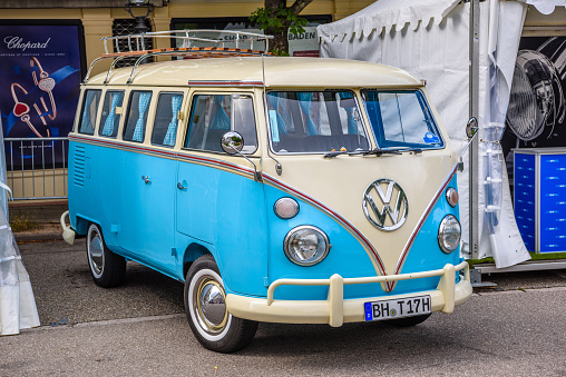 Baden-Baden, Germany - 14 July 2019: white beige blue Volkswagen VW Type 2 T1 microbus small bus 1966 1950 1967 is parked in Kurpark in Baden-Baden at the exhibition of old cars 