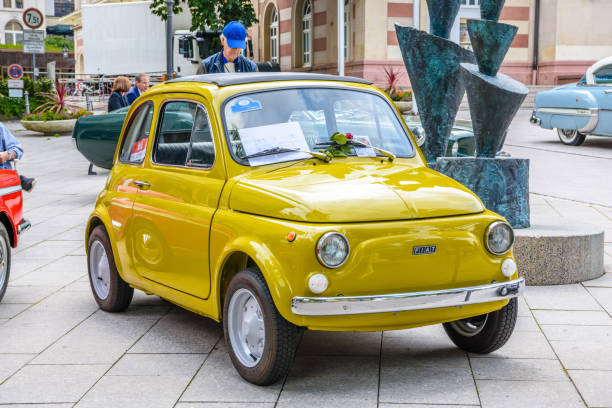 small yellow Fiat 500 Topolino 1957 1975 Baden-Baden, Germany - 14 July 2019: small yellow Fiat 500 Topolino 1957 1975 is parked in Kurpark in Baden-Baden at the exhibition of old cars "International Oldtimer Meeting Baden-Baden 2019" fiat 500 topolino stock pictures, royalty-free photos & images