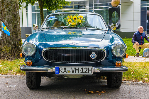 Baden-Baden, Germany - 14 July 2019: dark blue Glas GT 1300 GT1300 cabrio with flowers on the hood is parked in Kurpark in Baden-Baden at the exhibition of old cars \