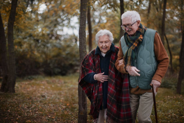 istock Senior couple walking together in autumn forest. 1440953916
