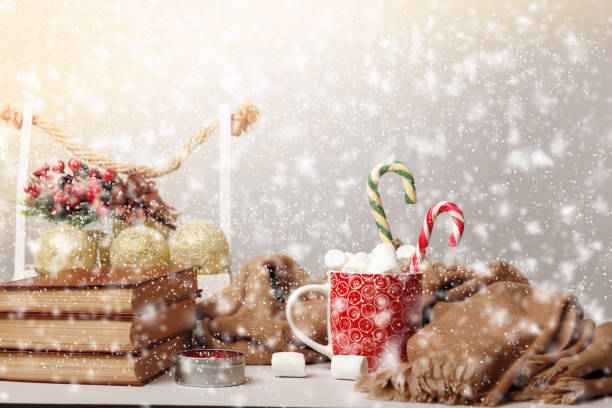 istock Merry Christmas. Mug with marshmallows and stack of books with defocused snowfall. 1440956280