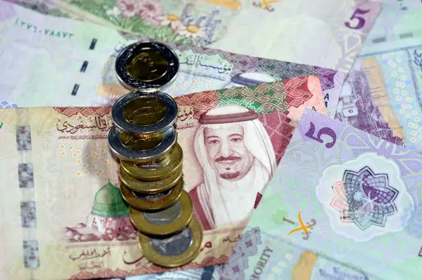 Saudi Arabia riyals money banknotes and coins, a pile of 500 SAR, 100 Saudi riyals and 5 riyals with 1, 2 riyals coins features king Salman bin AbdulAziz and king AbdulAziz, Saudi money exchange rate, selective focus