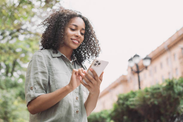 istock Happy woman using smart phone in a city 1440958016