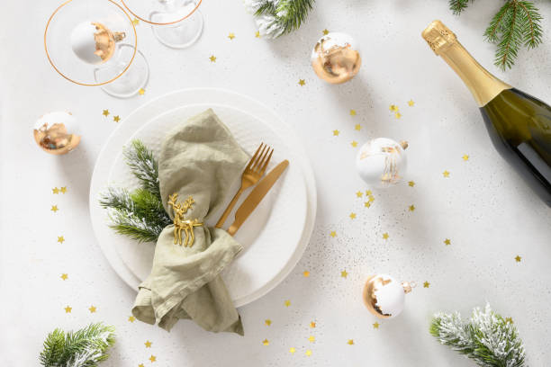 weihnachtstisch gedeckt mit goldenen kugeln, flasche champagner auf weiß. - nobody table knife food dinner stock-fotos und bilder