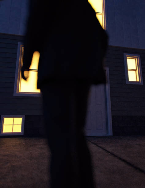 istock Lone man in suit stands by an illuminated house at dusk. Rear view. 3D render. 1440961612