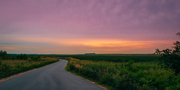 Sunset in the field with curved road in Big Stone National Wildlife Refuge in Odessa, Minnesota, USA