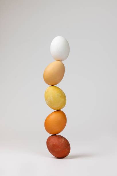 istock Vertical shot of Easter eggs stacked on top of one another on a white background 1440964535
