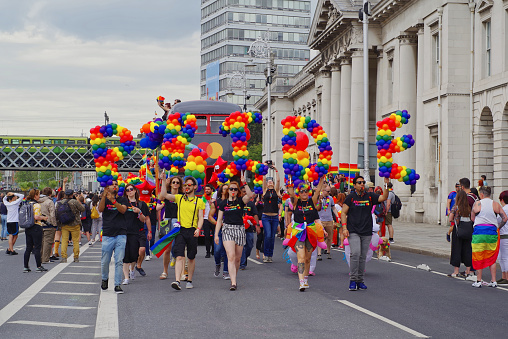 Dublin, Ireland – June 29, 2019: Participants of the Dublin LGBTQ Pride Festival hold colorful letters that form the word PRIDE. The letters are made of balloons in a rainbow pattern.